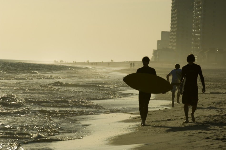 View along Orange Beach, Alabama at sunset with surfers in view